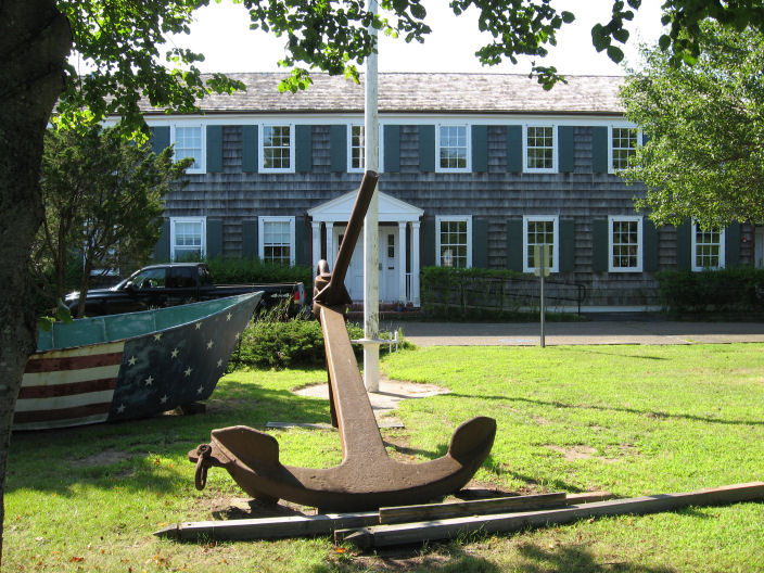 A boat and anchor on lawns highlighting the Rams Head Inn's boat docking in Shelter Island.